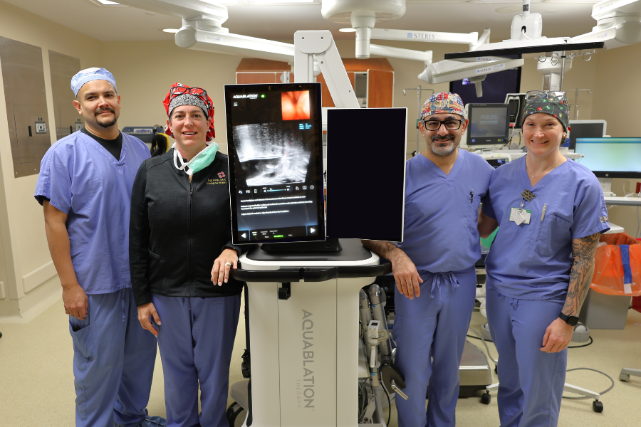 Health care providers standing beside new aquablation system