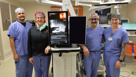 Health care providers standing beside new aquablation system